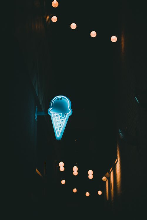 Free Dramatic street view with an ice cream neon sign glowing at night, creating a moody ambiance. Stock Photo