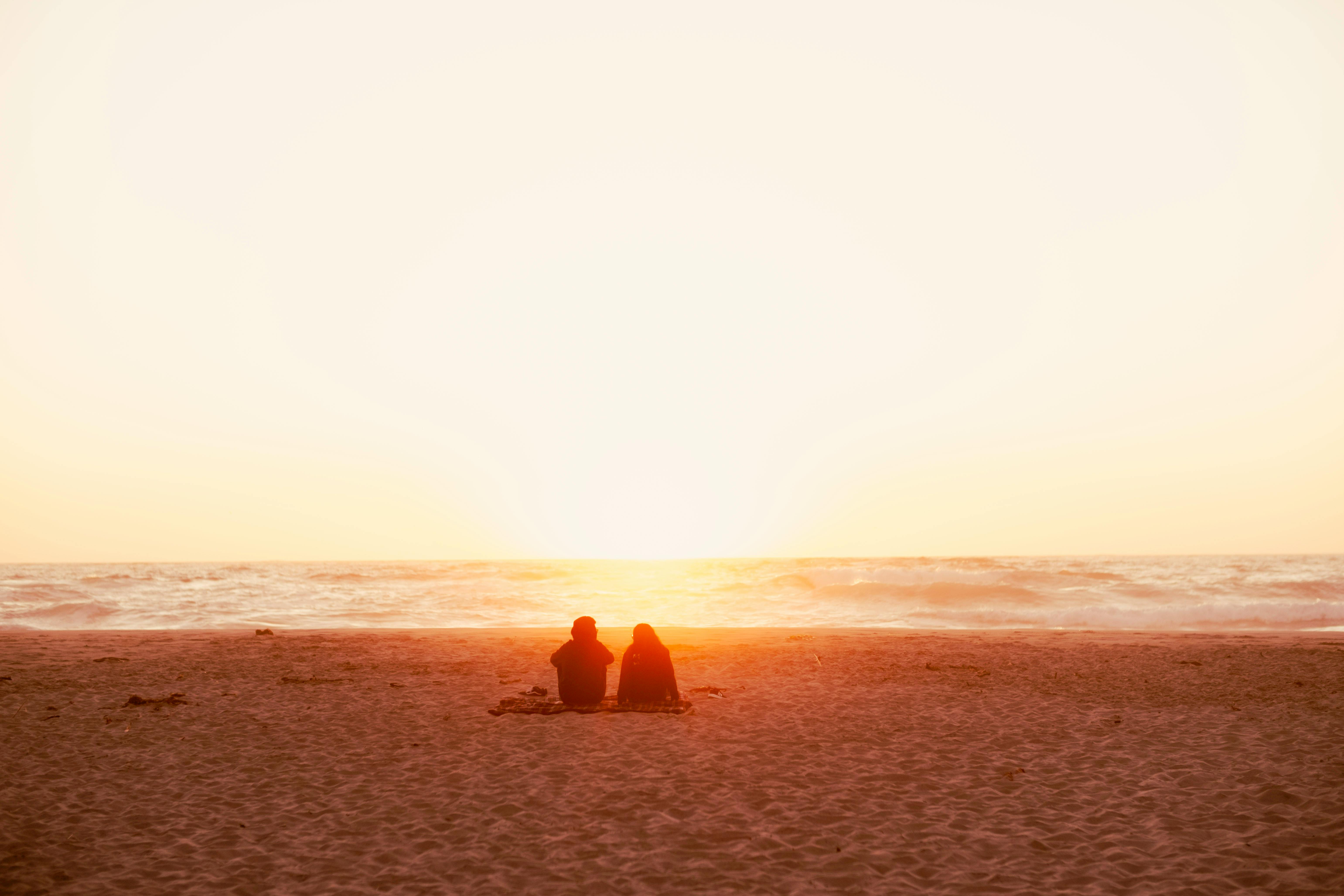 A Couple Sitting on the Grass Field · Free Stock Photo