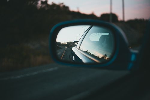 Free A tranquil road with blurred background is reflected in a car's side mirror. Stock Photo