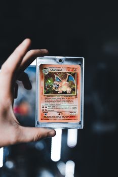 A detailed view of a Charizard Pokémon card held by a hand, iconic and collectible.