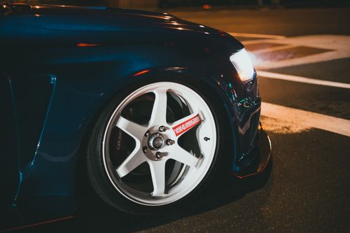 Free Detailed view of a dark blue modified car wheel with lights on at night. Stock Photo
