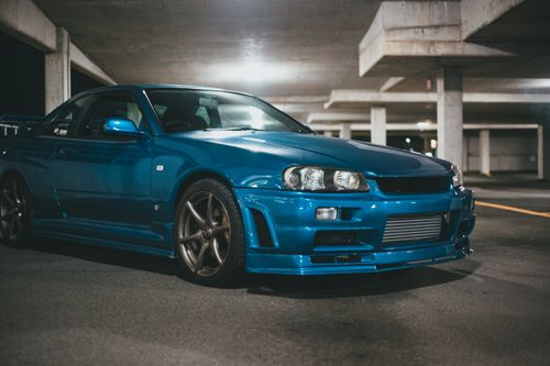 Free A sleek blue sports car parked in a dimly-lit underground garage, showcasing elegant design and speed. Stock Photo