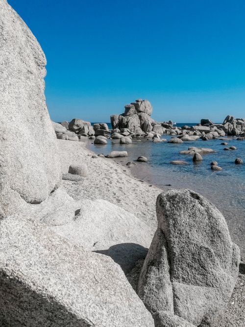 Free Breathtaking view of rocky formations against a vivid blue sky at the seashore. Stock Photo