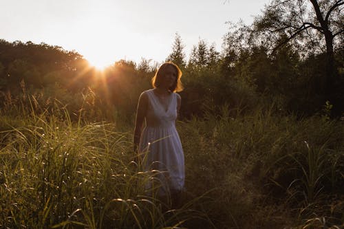 Woman in White Dress Standing on Green Grasses
