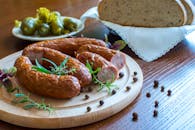 木盘上放着烟熏香肠，搭配面包和泡菜，非常适合乡村美食