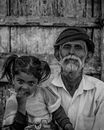 Grayscale Photo of Bearded Man with a Girl Beside him Sitting