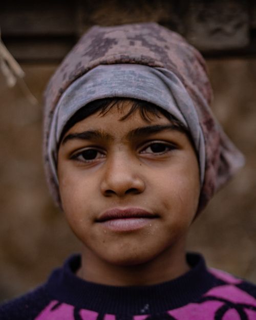 Free Close-up portrait of a young boy wearing a headscarf, looking into the camera. Stock Photo