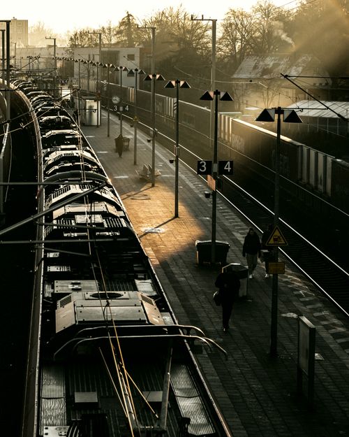 Free High angle view of a train station during golden hour with commuters on the platform. Stock Photo
