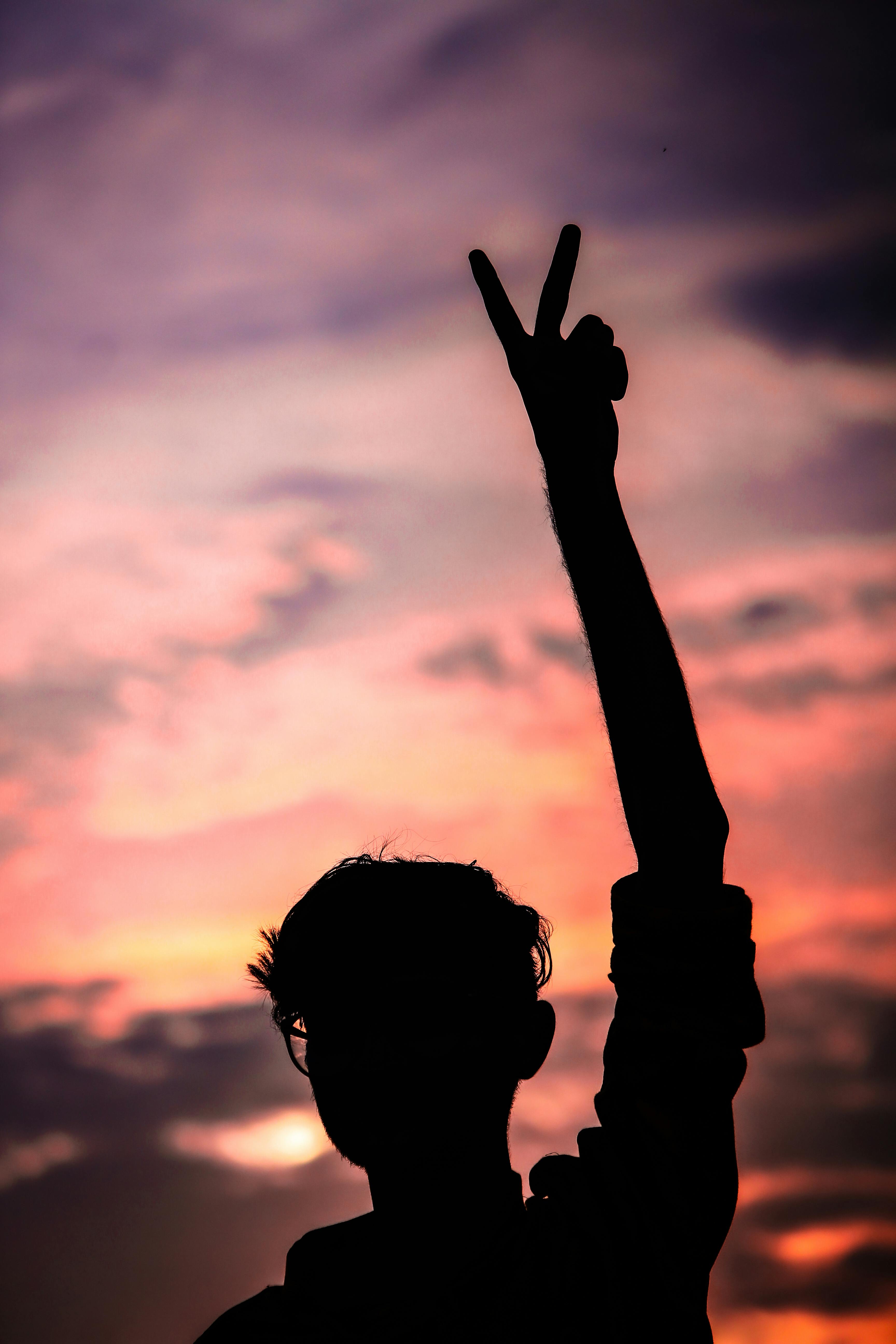 silhouette of a person raising his hand