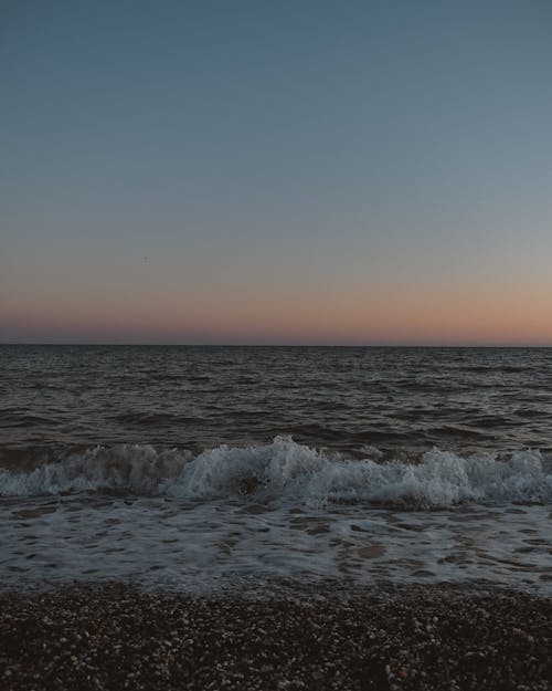 Waves Crashing on Shore During Sunset