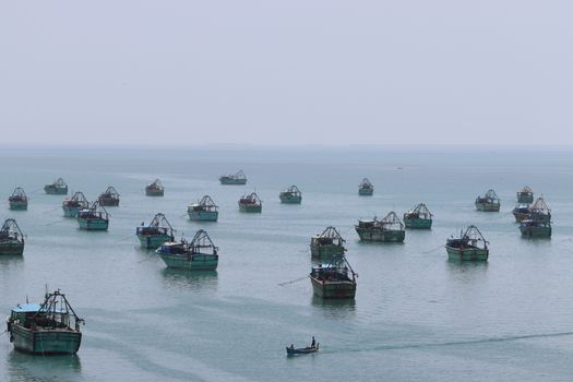 An array of fishing boats anchored on the serene waters off Rameswaram, India.