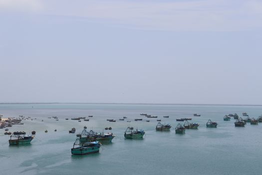 Serene aerial view of fishing boats in Rameswaram's clear blue waters.