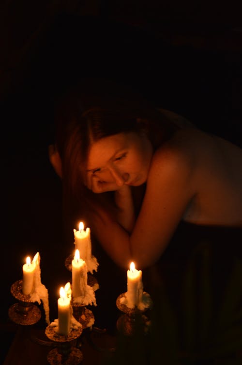 Free Shirtless Woman Looking at Lighted Candles Stock Photo