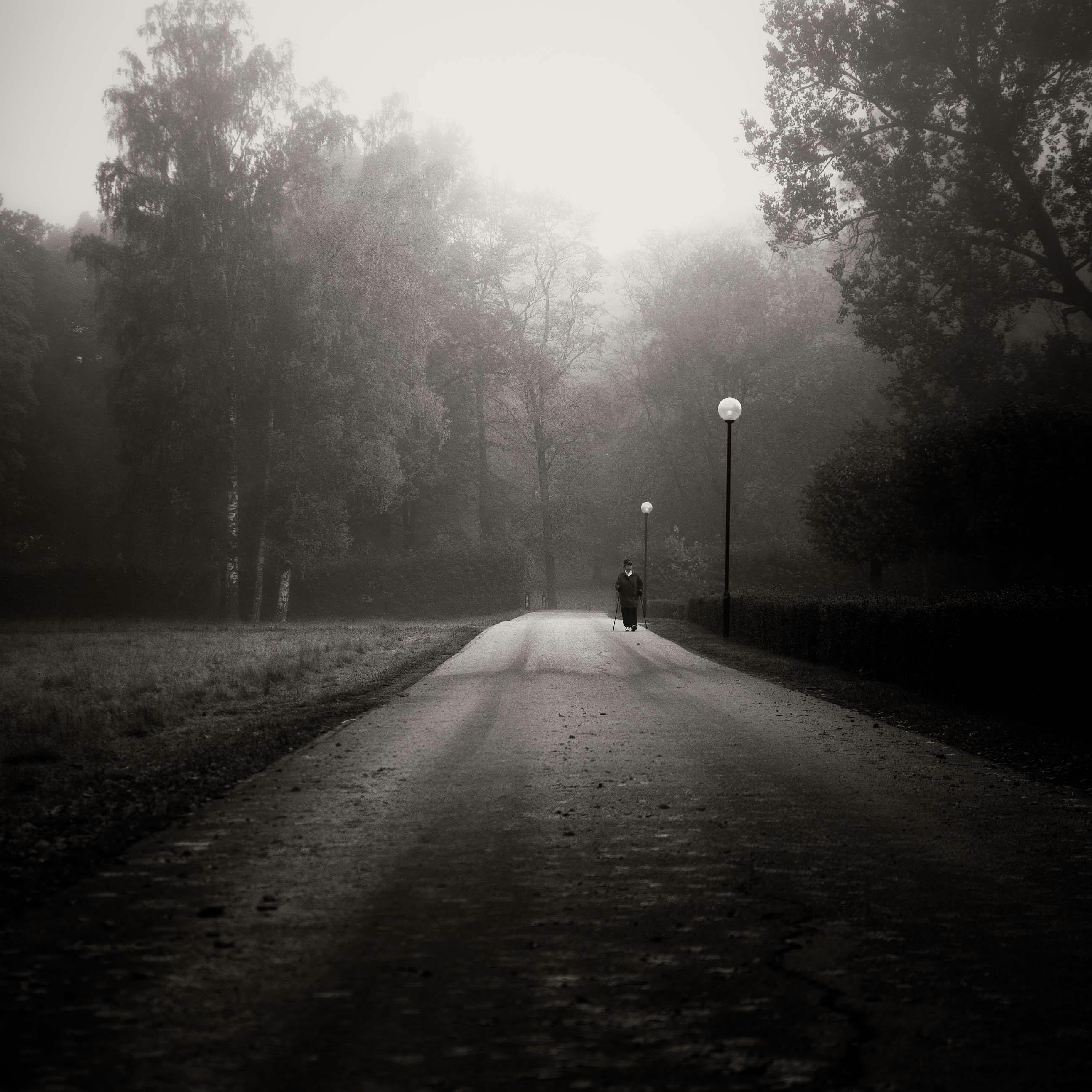 Grayscale Photo of a Person Walking on a Foggy Street · Free Stock Photo