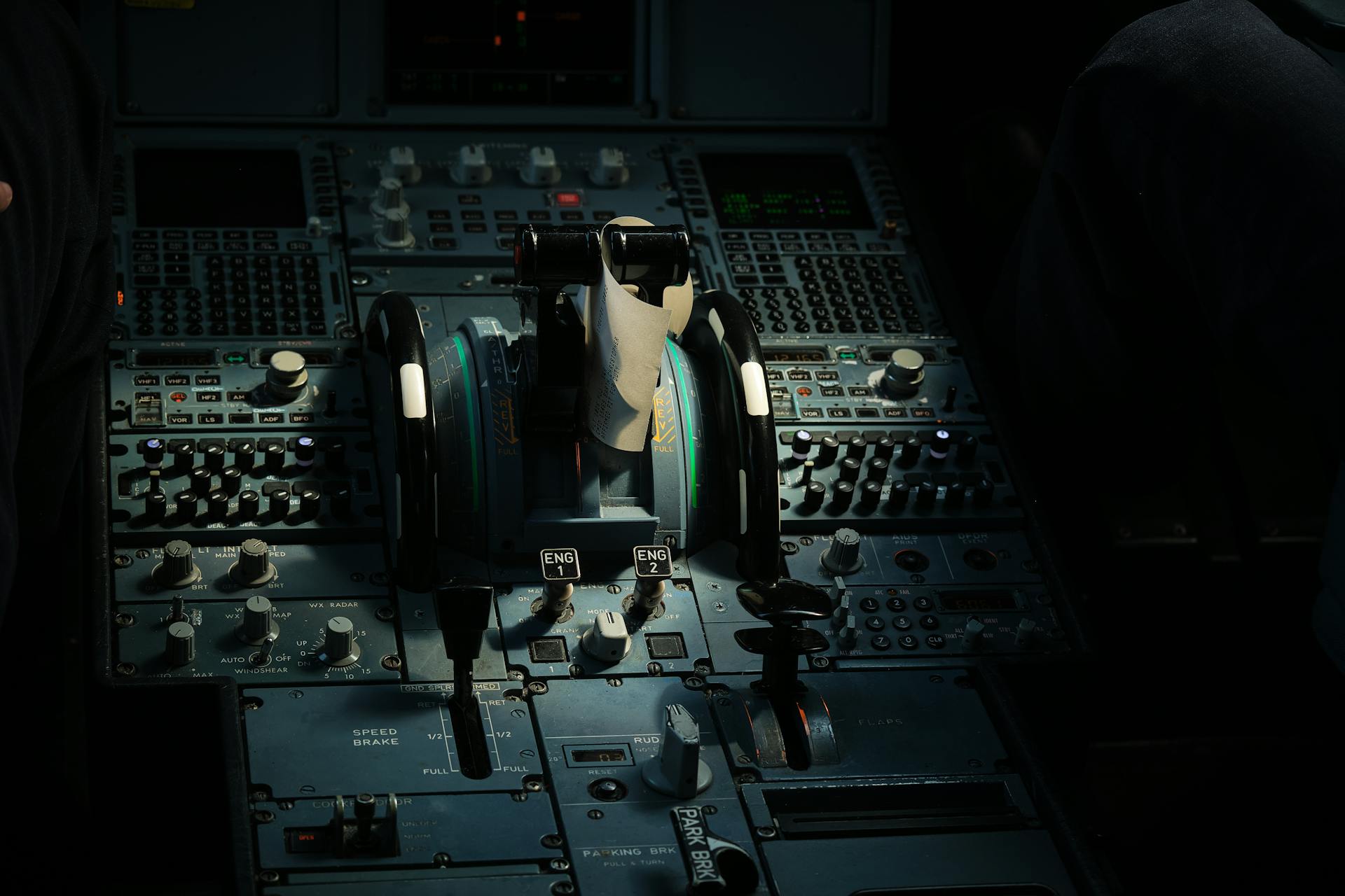 Detailed view of airplane cockpit control panel with levers and switches.