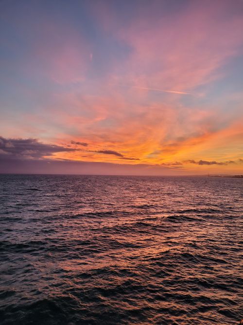 Free Captivating sunset over the ocean, showcasing vibrant hues and a dramatic sky. Stock Photo