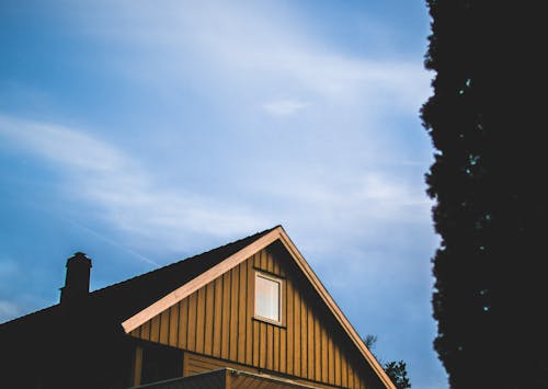 無料 昼間の青い空の下で茶色の木造住宅 写真素材