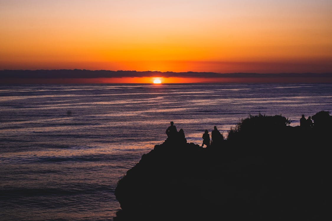 Silhouette of People on Mountain Looking at Sunset View