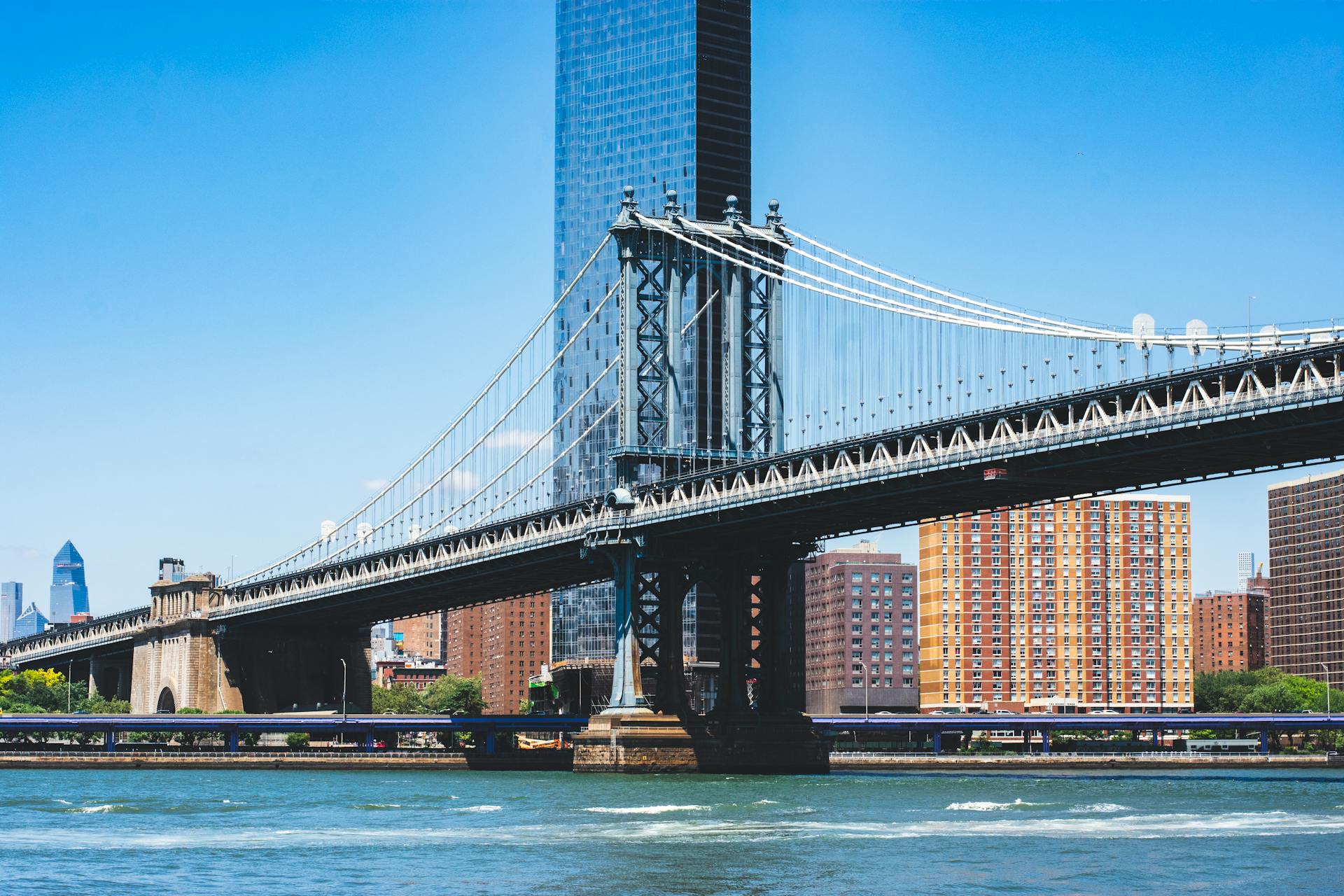 Manhattan Bridge spanning over the East River with New York City skyline in the background.