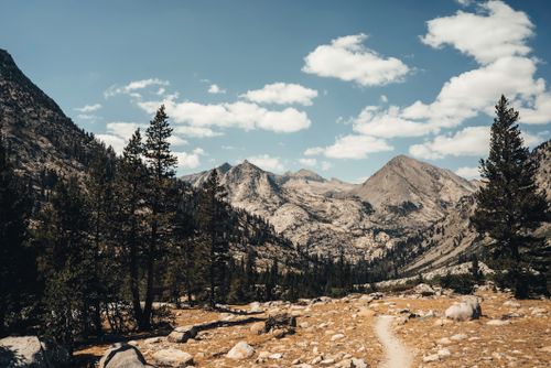 Free Scenic landscape of Yosemite Valley with mountaintops, trees, and a clear blue sky. Stock Photo