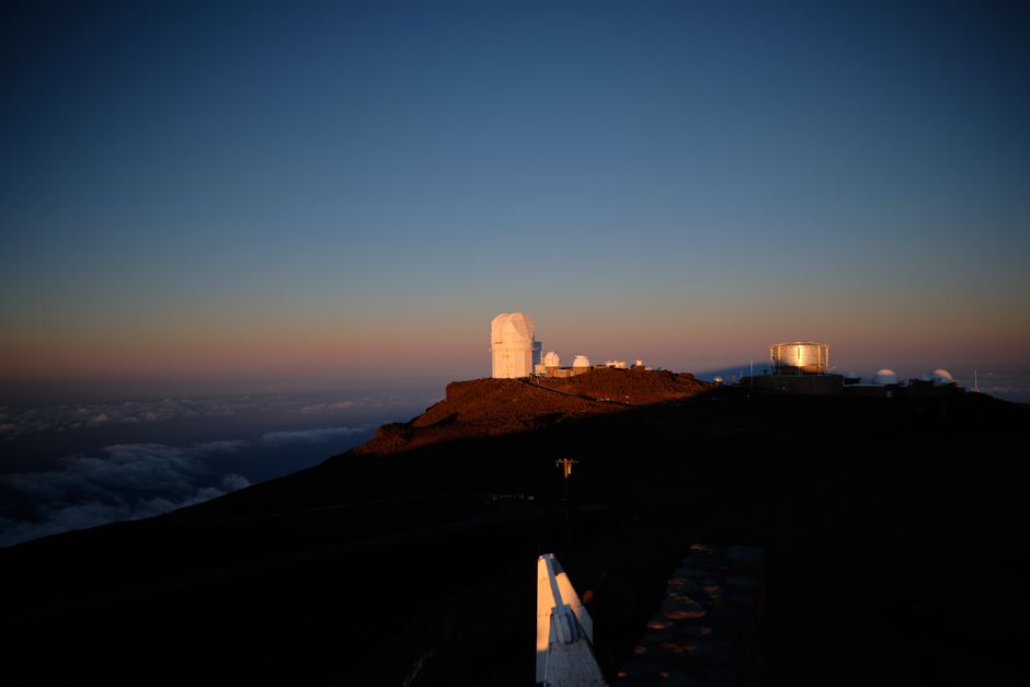 Photo by Owen DeRoos Aerial view of a Hawaiian observatory at sunset, with clear skies and hills.