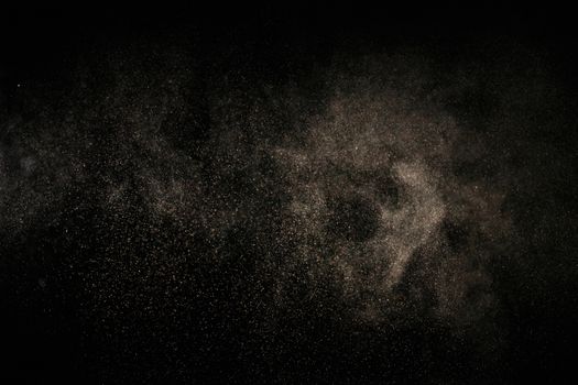 Abstract image of fine particles floating against a black background.