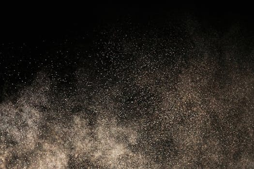 A mesmerizing display of dust particles floating against a dark backdrop, creating a textured effect.