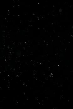 A dark abstract image showcasing droplets against a black background.