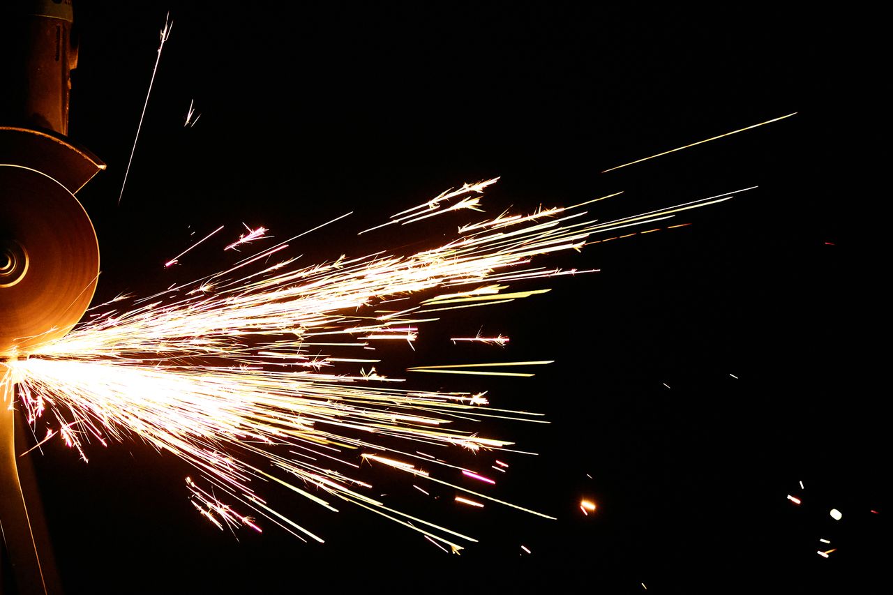 a close up shot capturing dazzling sparks flying from an angle grinder