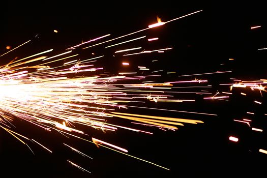Captivating sparks flying sideways on a black background, showcasing movement and energy.