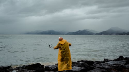 Anonymous fisherman catching fish on water