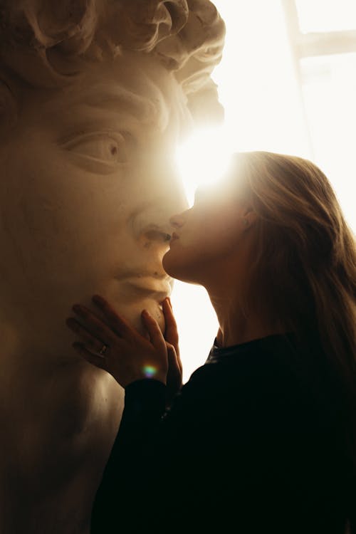 Adult woman touching marble scultpure