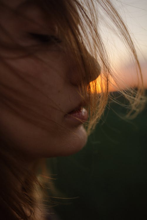 Close up on womans face covered with winded hair