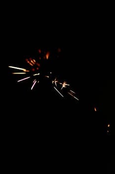 Vibrant sparkler lights sparkle against a black background, creating a dazzling and festive effect.