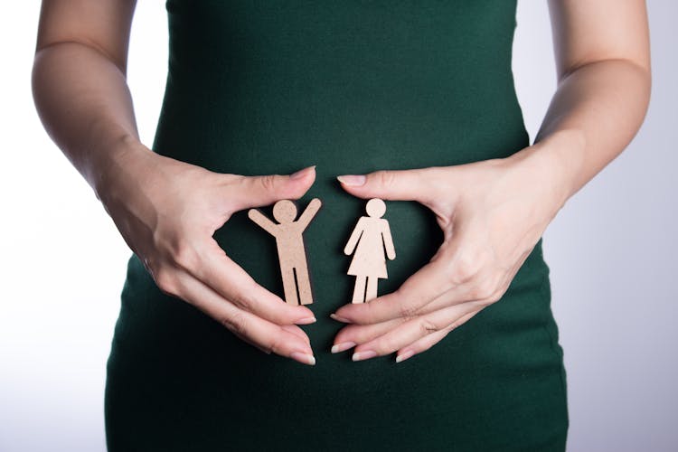 Woman Hands Holding Wooden Dolls Of Woman And Man