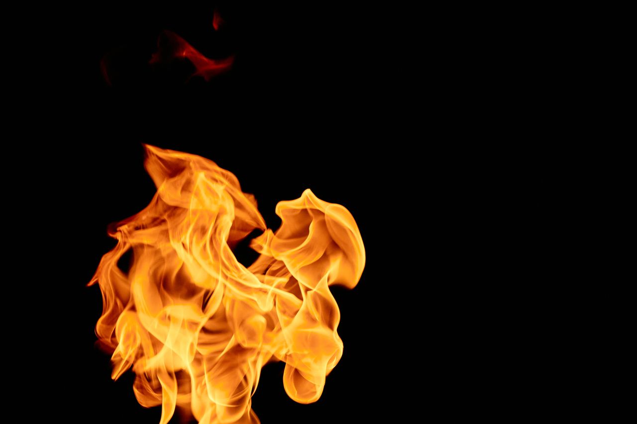 close up of vibrant flames isolated against a black backdrop showcasin