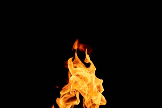 A captivating image of vibrant flames isolated against a dark black background.