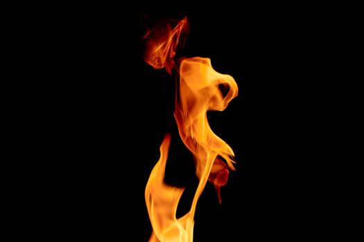 Close-up of vivid flames swirling against a black backdrop, capturing intense heat and movement.