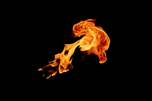 Free Dynamic close-up of vivid orange flames against a black backdrop, capturing the enthralling dance of fire. Stock Photo