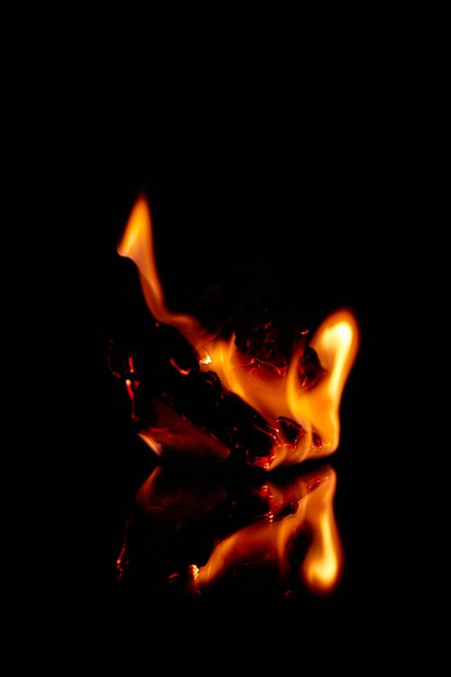 Free Intense flames reflecting on a dark background creating a dramatic visual effect. Stock Photo