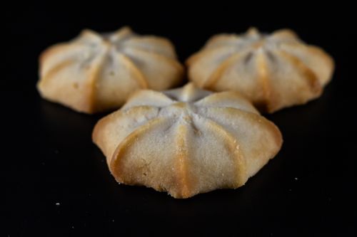 Free Three homemade shortbread cookies beautifully arranged on a black surface. Stock Photo