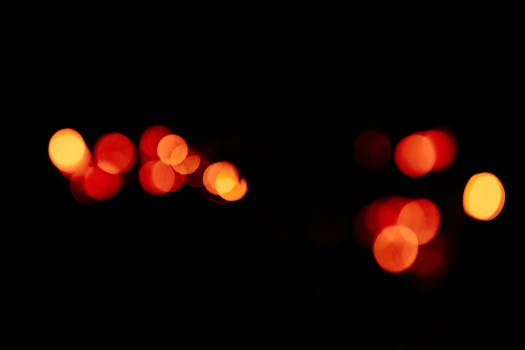 Abstract bokeh light composition with orange hues against a black background. Perfect for vibrant backgrounds.