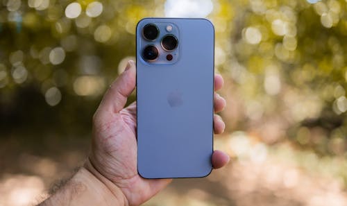 Free Person Holding an Iphone 13 Stock Photo