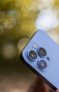 A close-up view of a smartphone camera lens with a vibrant blurred bokeh background.