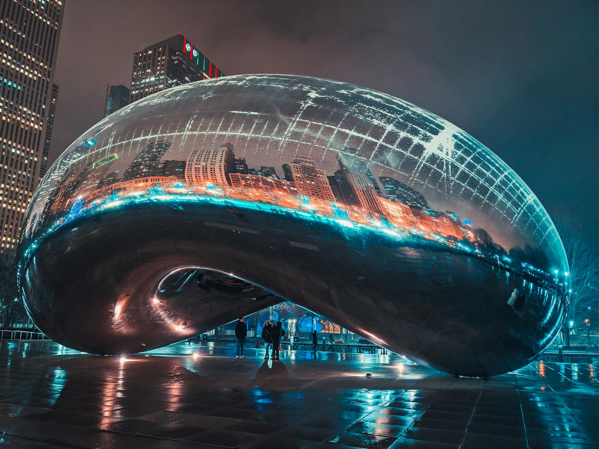 Stunning night view of Cloud Gate reflecting the illuminated Chicago skyline. Perfect for travel and urban exploration themes.