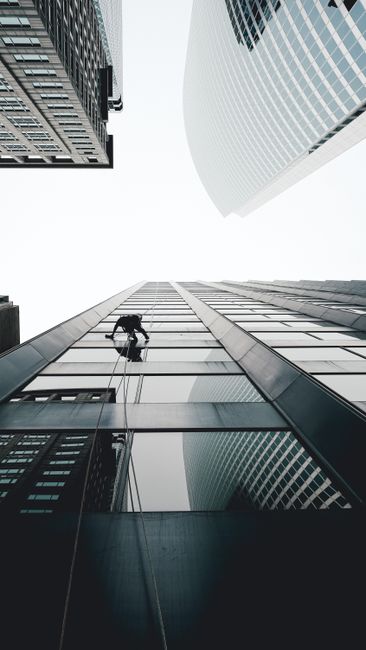 Window cleaner scaling skyscraper in Chicago, featuring modern architecture and urban perspectives.