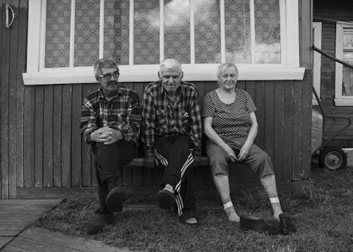 Grayscale Photo of Elderly People Sitting Beside Each other