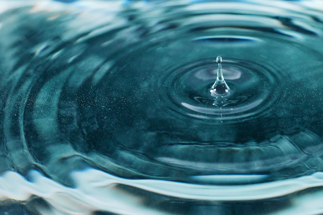 穏やかな水に落ちる水滴のクローズアップ写真