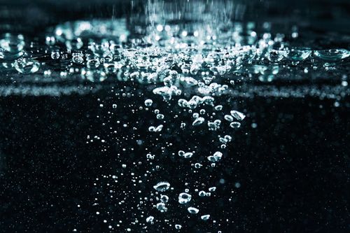 Free A detailed macro shot of effervescent bubbles rising in water, showcasing fizz and movement. Stock Photo
