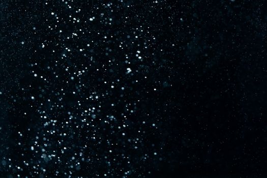 Abstract image of water droplets resembling a starry night sky with a dark backdrop.